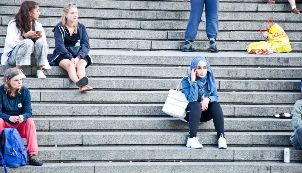 Jeune femme voilée sur les marches de la cathédrale Saint-PIerre à Cologne. / IStock